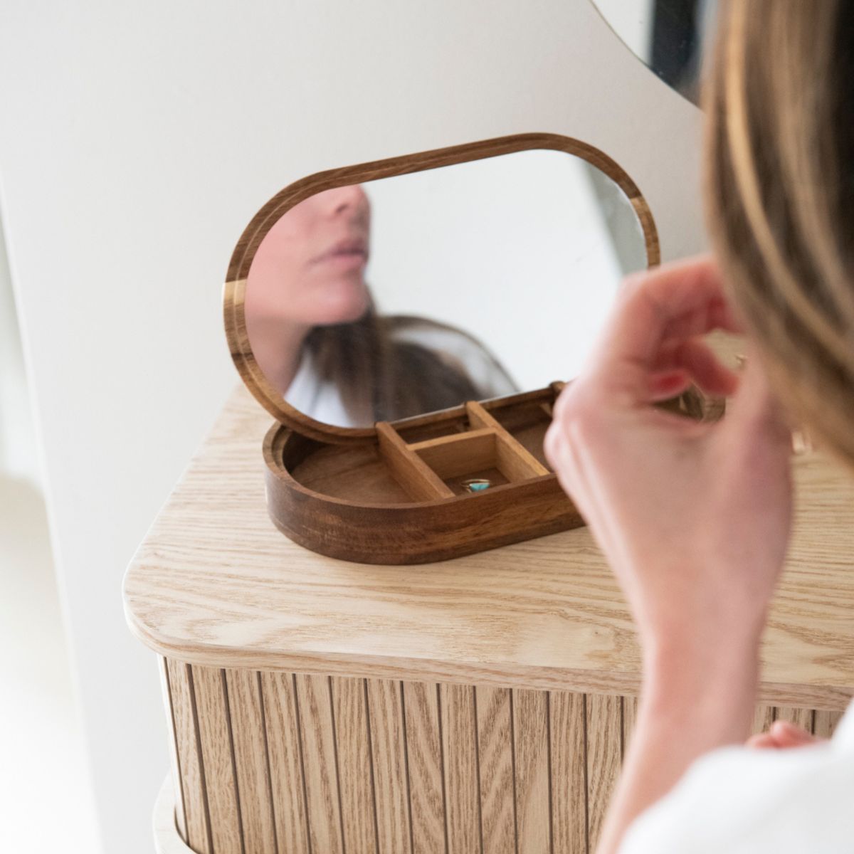 Joyero de acacia con espejo en un tocador 