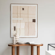 Cuadro decorativo textil en tonos beige y crudo con detalles marrones en ambiente de estilo natural