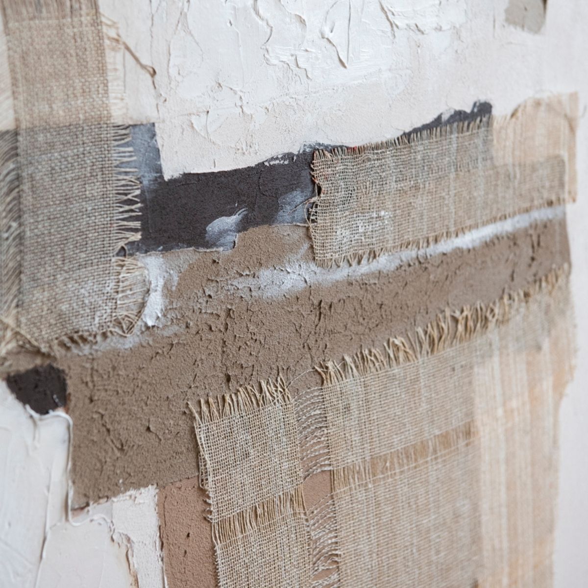 Detalle de texturas y aplicaciones textiles de cuadro abstracto en tonos beige y blanco