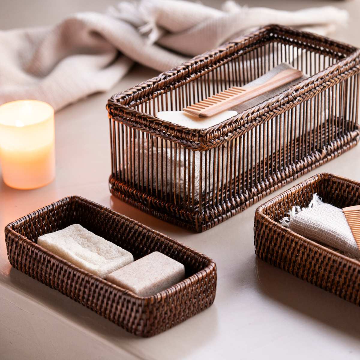 Bandejas y caja de ratán con accesorios de baño