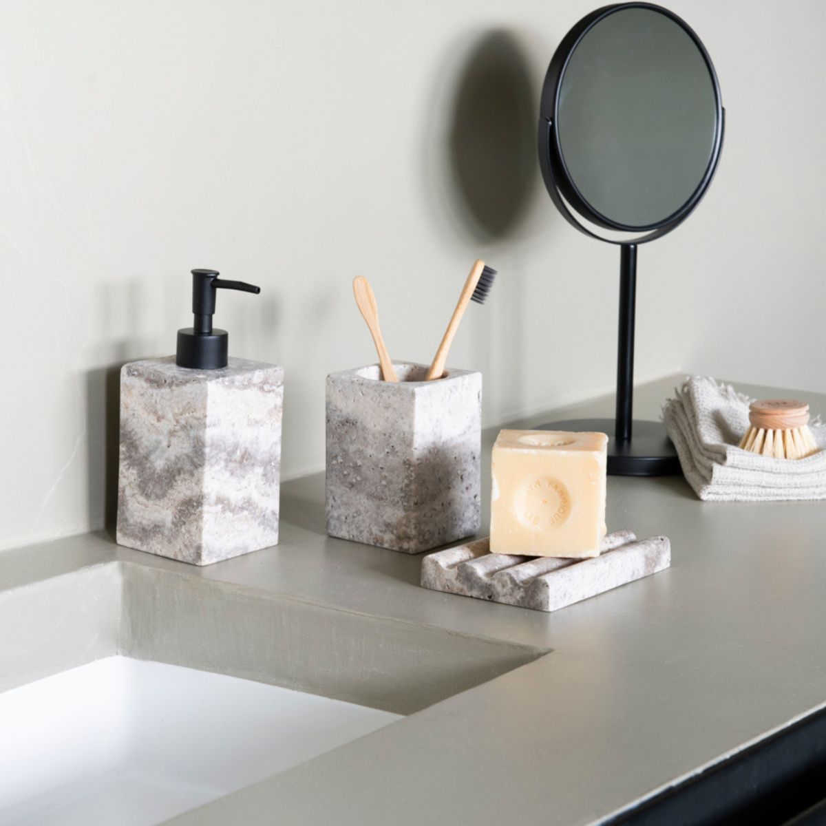 Dispensador de mármol gris cuadrado en baño poderno de cemento