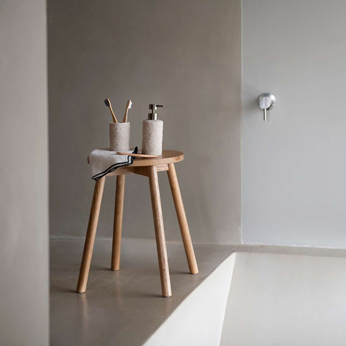 Baño con accesorios de baño y taburete de madera