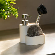 Organizador de fregadero beige con dispensador de jabón, cepillo y compartimento para estropajo.