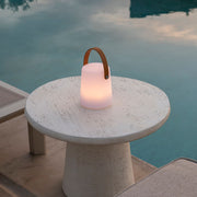 Lámpara LED inalámbrica con remoto sobre mesa de exterior con piscina 