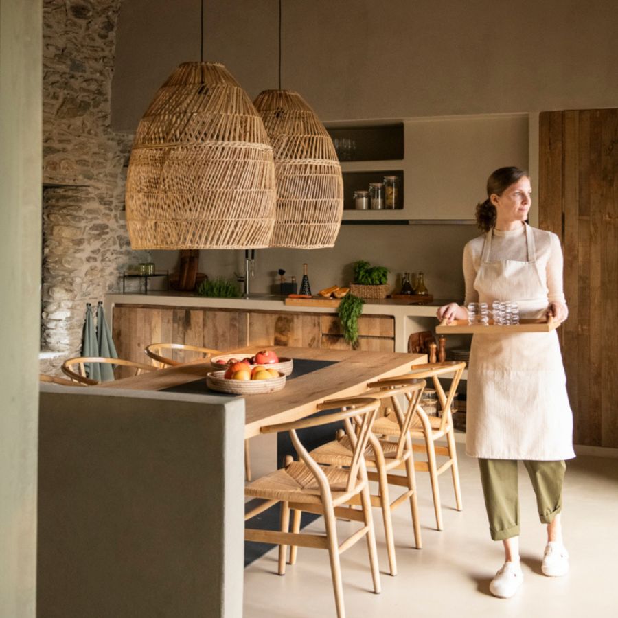 Mujer sosteniendo bandeja de bambú para servir en cocina rústica