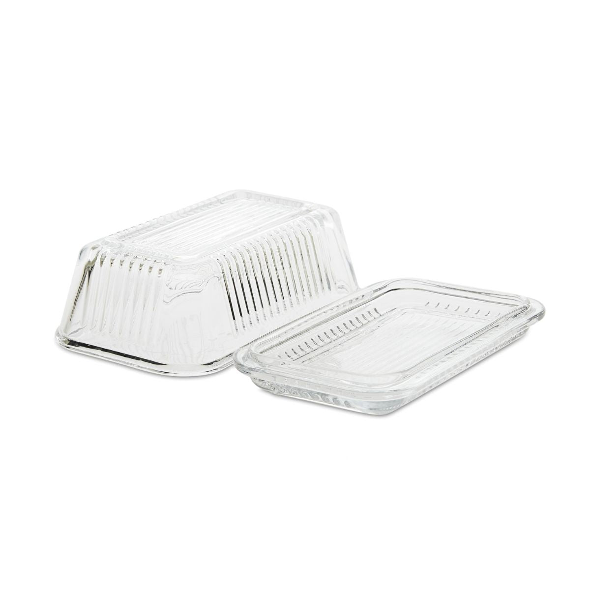 Mantequillera de vidrio transparente con base y tapa acanalada desmontadas.