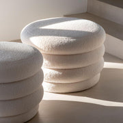 White upholstered storage pouf